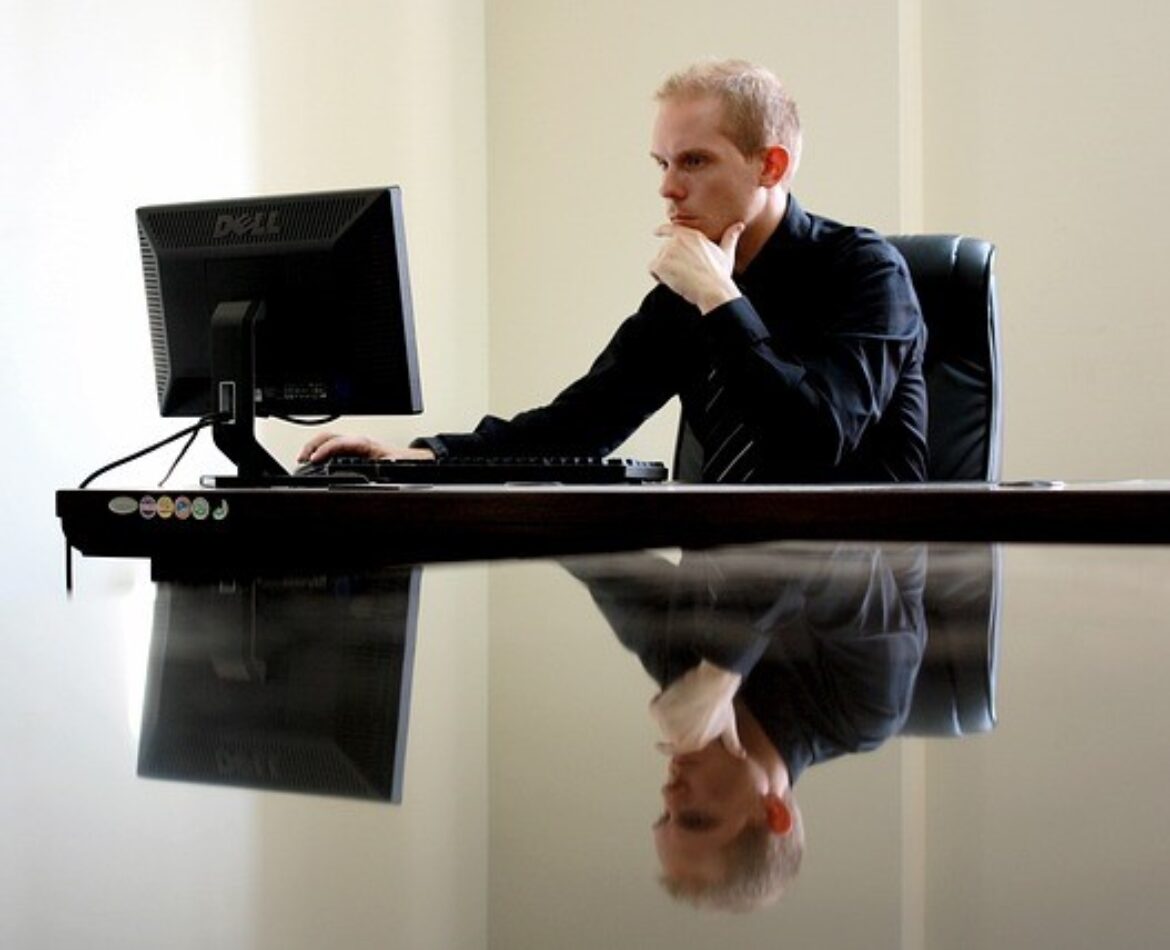 Candidat concentré sur son ordinateur en train de réussir le TOEIC Listening and Reading en ligne adaptatif pour obtenir la certification de langue anglaise.