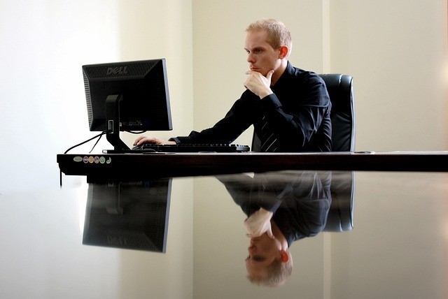 Candidat concentré sur son ordinateur en train de réussir le TOEIC Listening and Reading en ligne adaptatif pour obtenir la certification de langue anglaise.