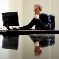 Candidat concentré sur son ordinateur en train de réussir le TOEIC Listening and Reading en ligne adaptatif pour obtenir la certification de langue anglaise.